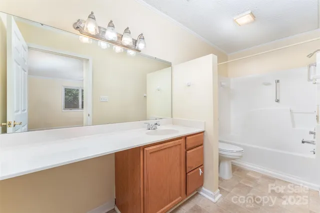 a bathroom with a sink a toilet a mirror and shower