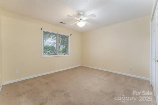an empty room with a window and a ceiling fan