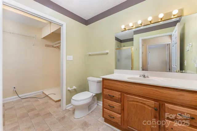 a spacious bathroom with a sink a toilet a mirror and shower