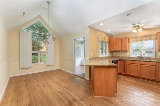 a view of a kitchen counter top space a sink wooden floor and a window
