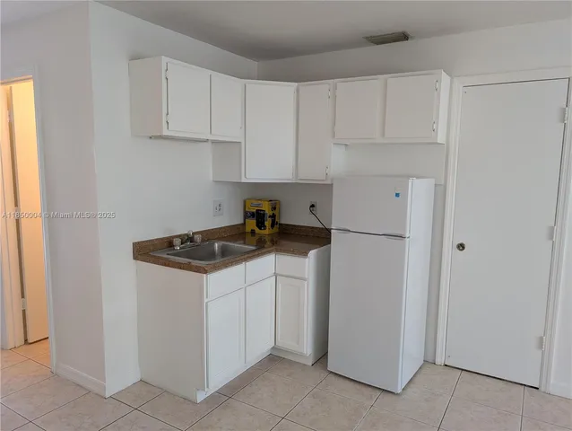 a view of a kitchen with white cabinets