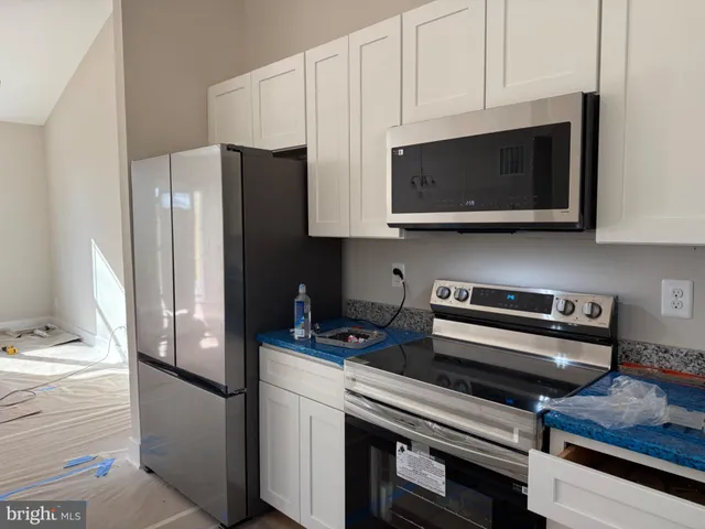 a kitchen with stainless steel appliances a refrigerator a stove a microwave and cabinets