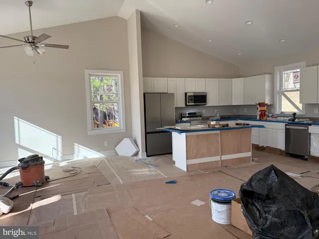 a kitchen with granite countertop a stove a sink and a refrigerator