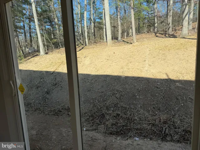 a view of a yard with wooden fence