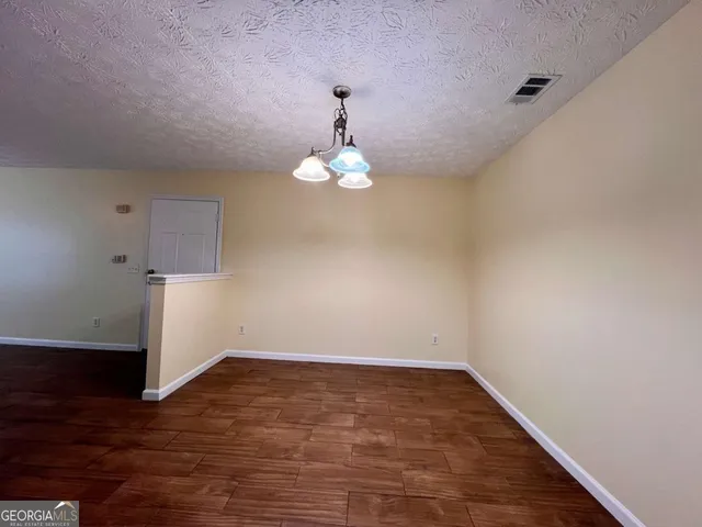 an empty room with a window and wooden floor