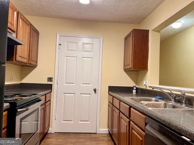 a kitchen with stainless steel appliances granite countertop a refrigerator and a stove