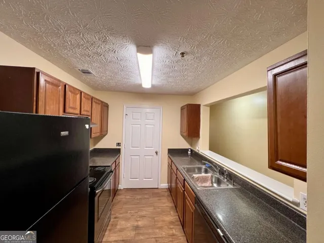 a kitchen with a refrigerator and a sink
