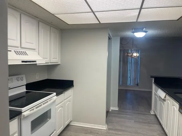 a kitchen with granite countertop a stove and a sink
