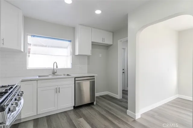 a kitchen with white cabinets and sink