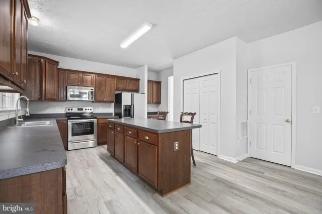 a kitchen with stainless steel appliances granite countertop a stove a sink dishwasher a refrigerator and a oven