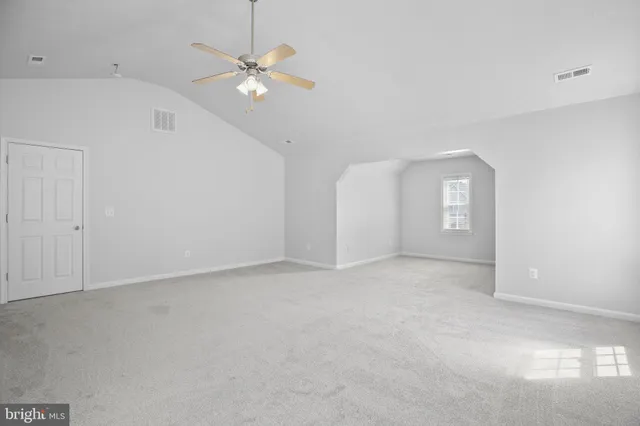 an empty room with fan and windows