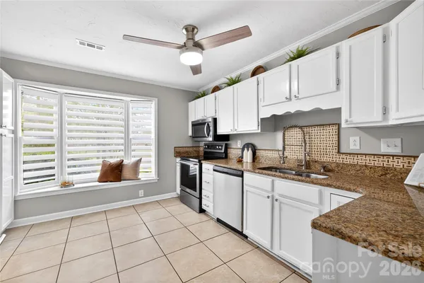 a kitchen with stainless steel appliances granite countertop a stove sink and cabinets