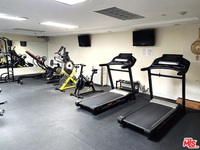 a room with gym equipment and large mirror
