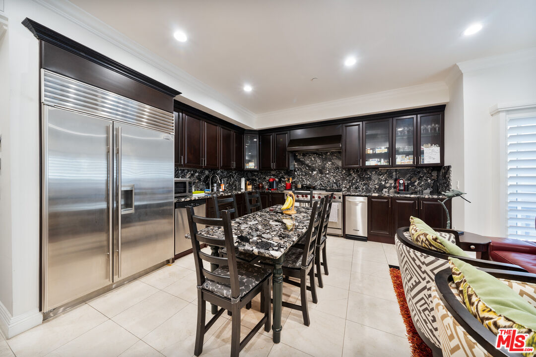 1043 South Kenmore Avenue, Unit 201 Los Angeles, CA 90006 - Photo 7 of 20 a kitchen with a refrigerator and a dining table
