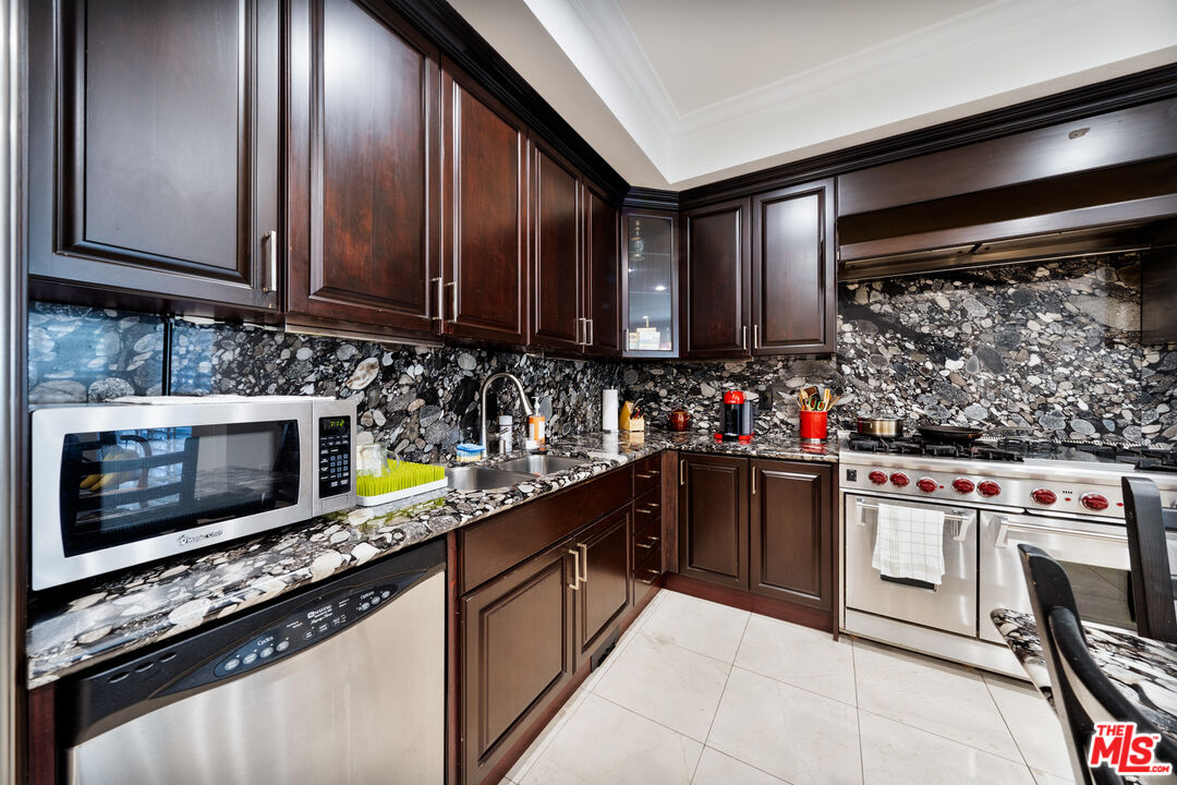 1043 South Kenmore Avenue, Unit 201 Los Angeles, CA 90006 - Photo 8 of 20 a kitchen with stainless steel appliances granite countertop a stove sink and cabinets