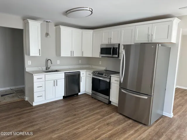 a kitchen with a refrigerator sink and cabinets
