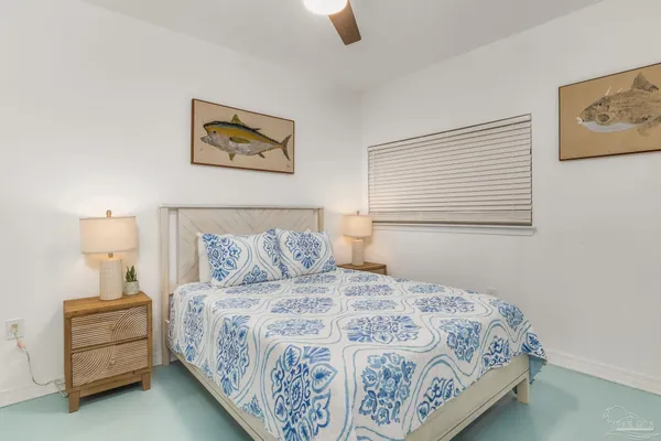 a bedroom with a bed and a lamp on dresser