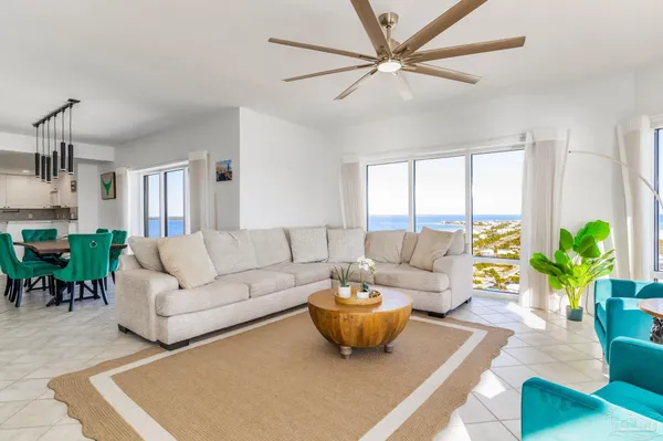 a living room with furniture a chandelier and a potted plant