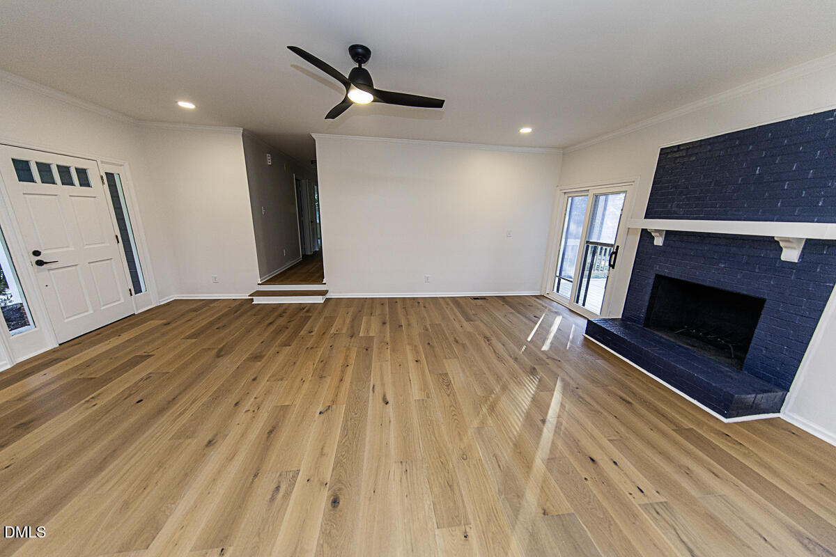 1208 Lorimer Road Raleigh, NC 27606 - Photo 11 of 37 a view of empty room with wooden floor and fireplace