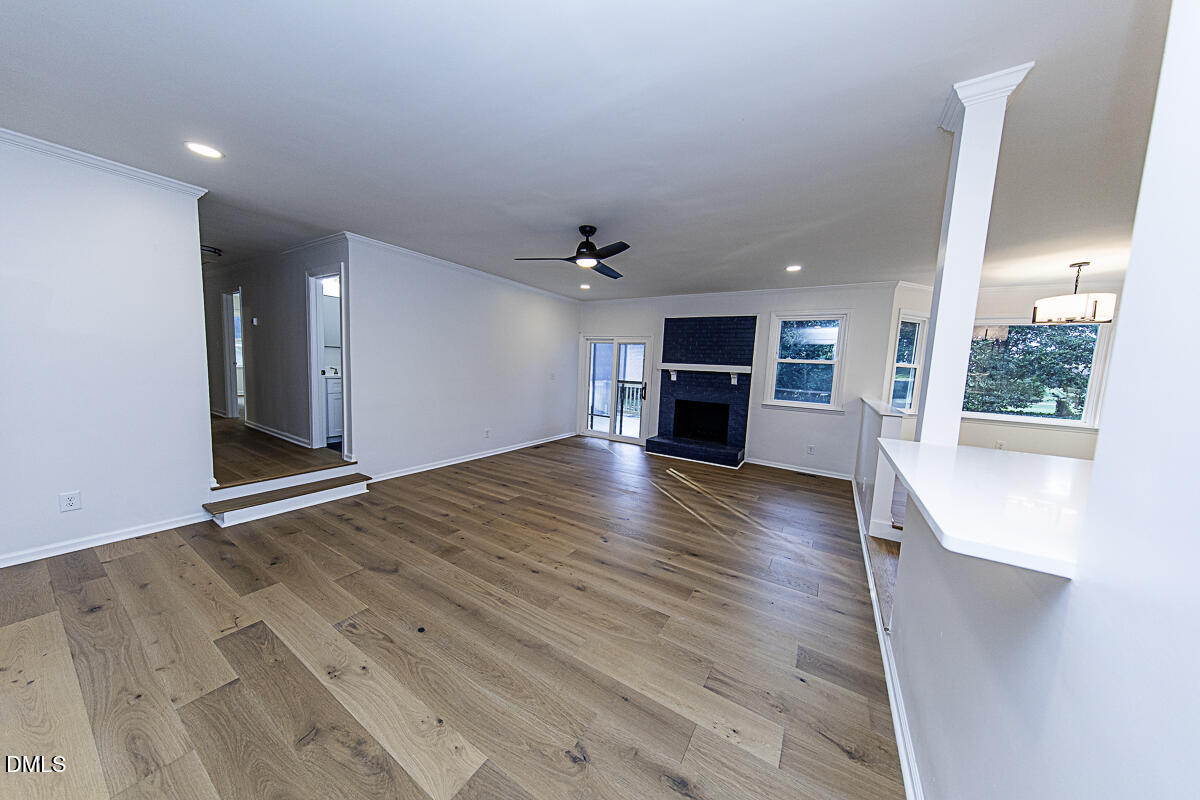 1208 Lorimer Road Raleigh, NC 27606 - Photo 13 of 37 an empty room with wooden floor kitchen view and a window