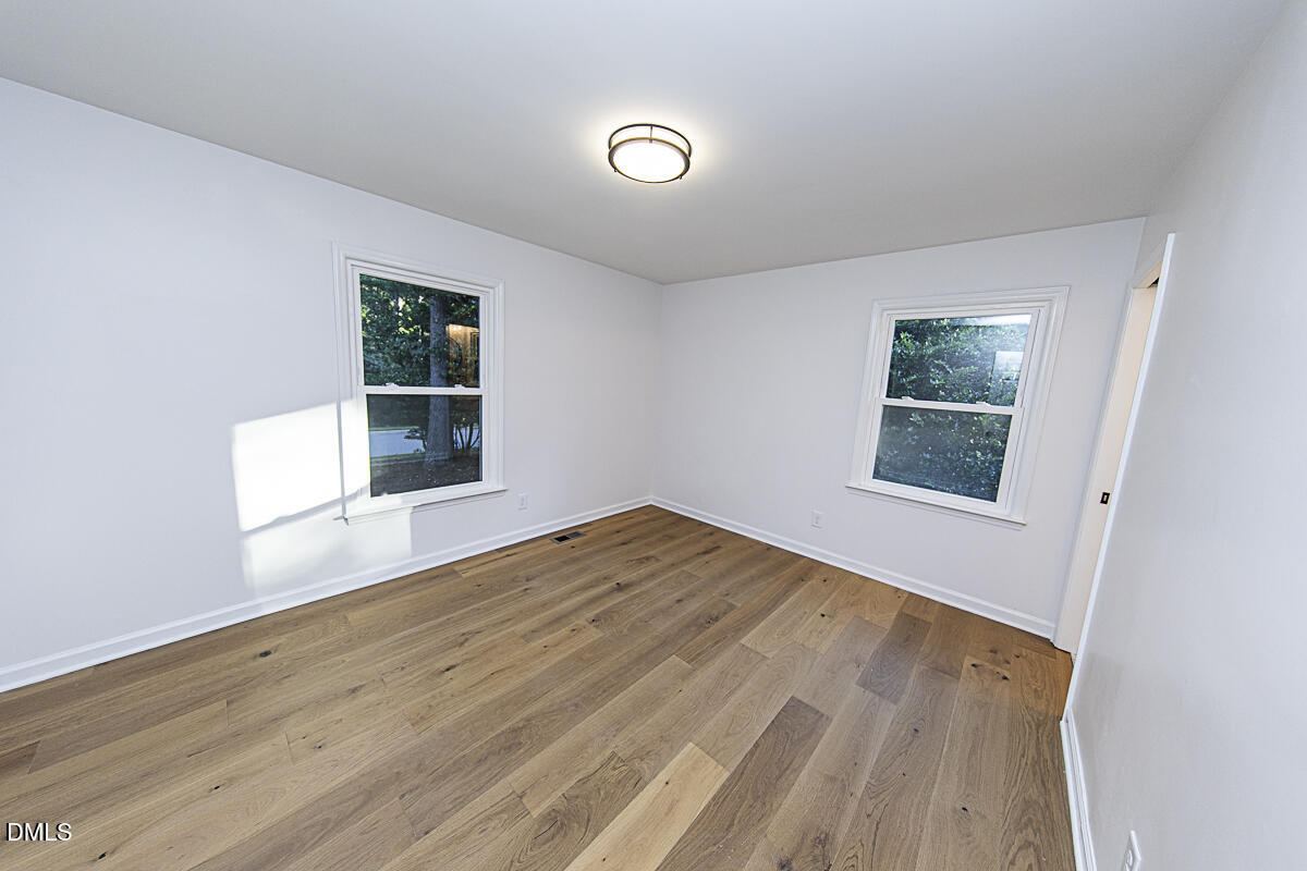 1208 Lorimer Road Raleigh, NC 27606 - Photo 21 of 37 a view of empty room with wooden floor and fan