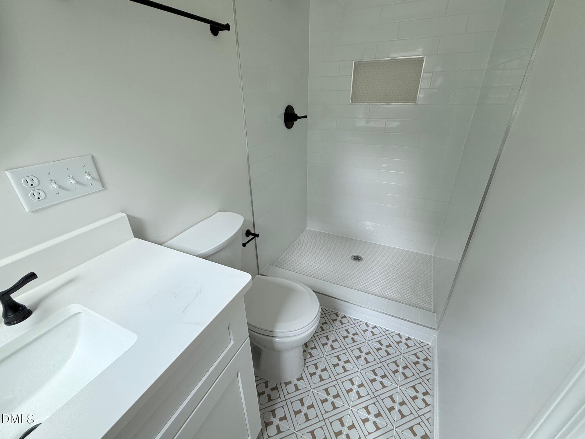 1208 Lorimer Road Raleigh, NC 27606 - Photo 23 of 37 a bathroom with a sink a toilet and shower