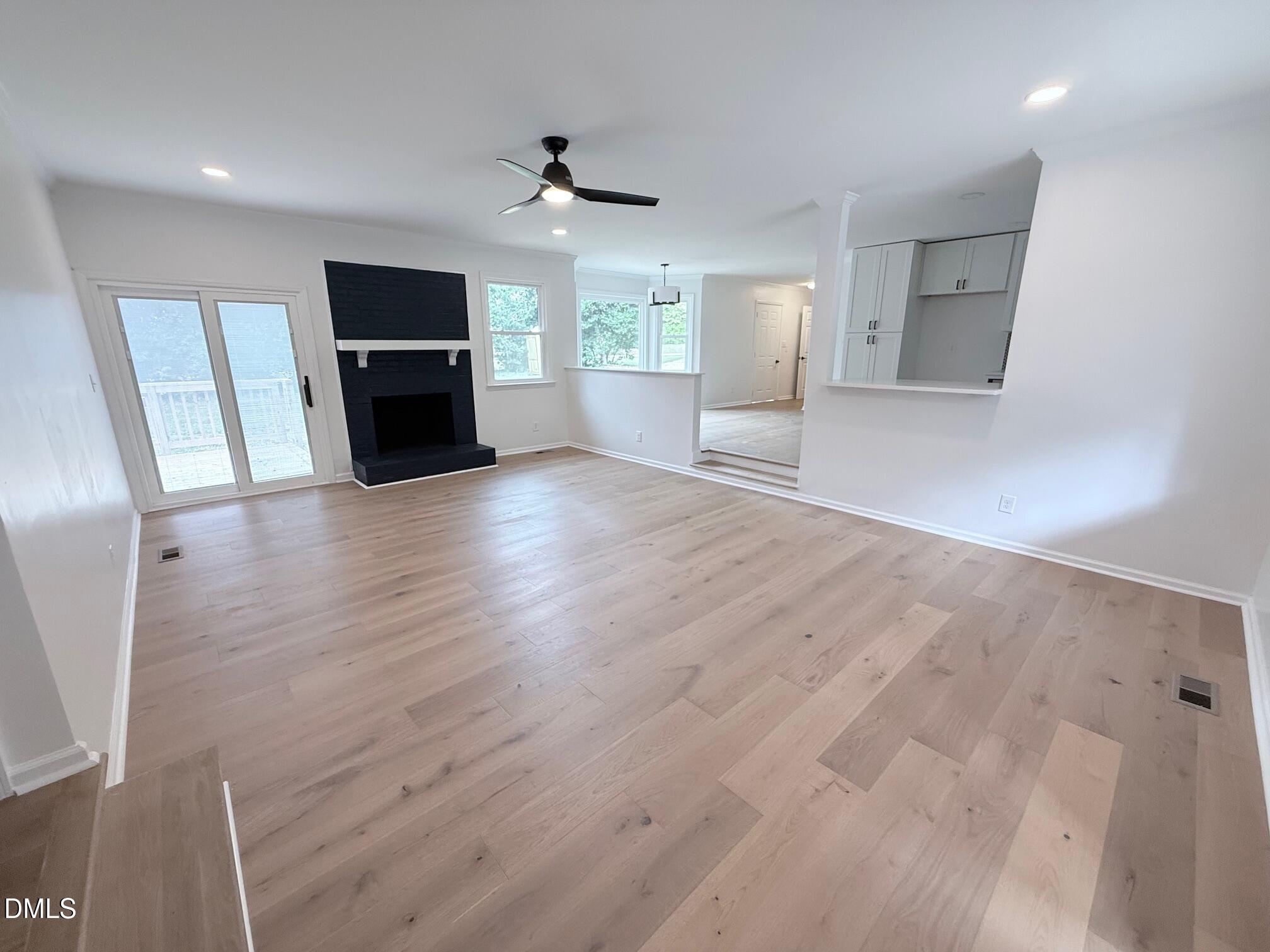 1208 Lorimer Road Raleigh, NC 27606 - Photo 27 of 37 a view of empty room with wooden floor and fireplace