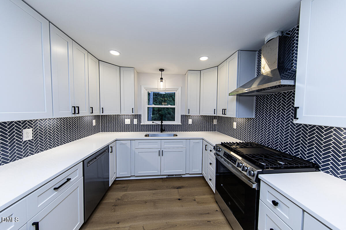 1208 Lorimer Road Raleigh, NC 27606 - Photo 9 of 37 a kitchen with a sink stove top oven and cabinets
