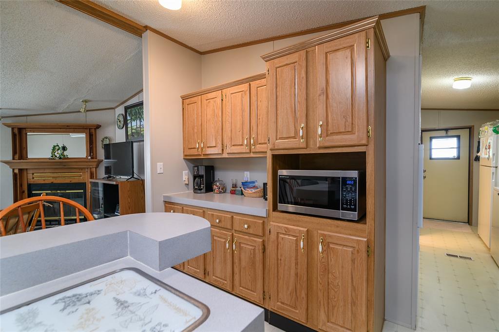 122 Grice Road Ringgold, LA 71068 - Photo 5 of 26 Kitchen featuring wood cabinetry, light-toned countertops, and a built-in microwave