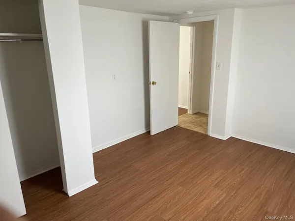 an empty room with wooden floor and closet