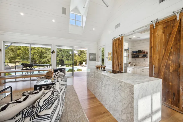 a view of a living room and kitchen floor to ceiling windows