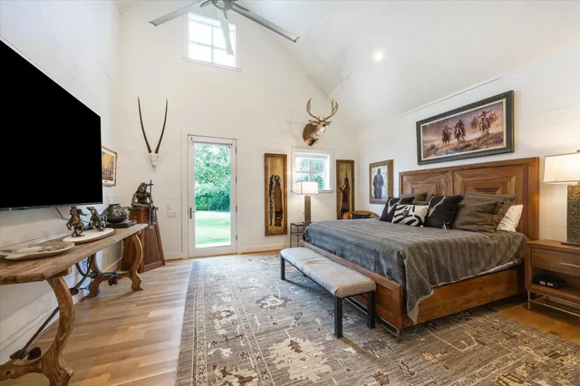 a spacious bedroom with a bed and a flat screen tv