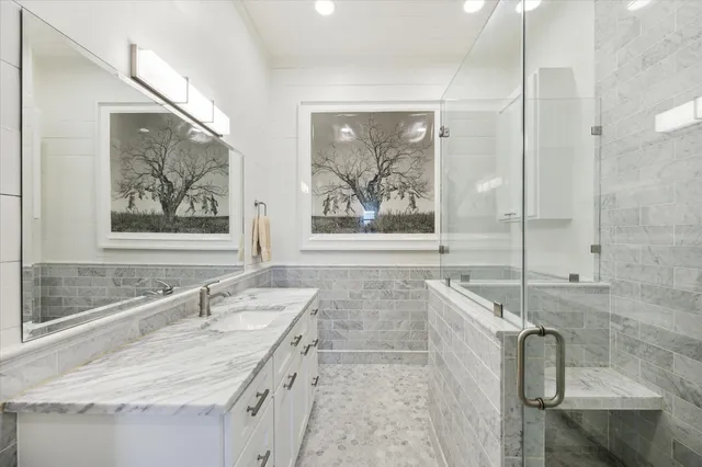 a bathroom with a granite countertop sink a large mirror and a bathtub