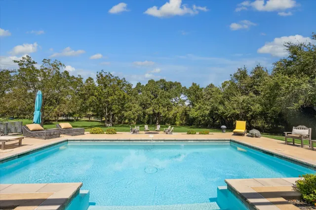 a view of a swimming pool with a lawn chairs
