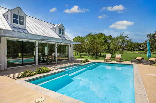 a view of a house with swimming pool and sitting area