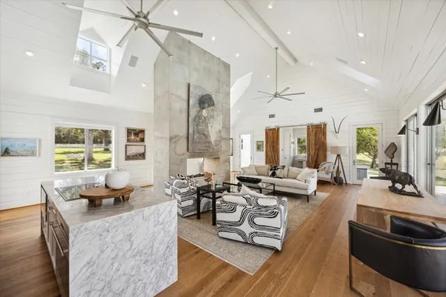 a living room with furniture kitchen view and a large window
