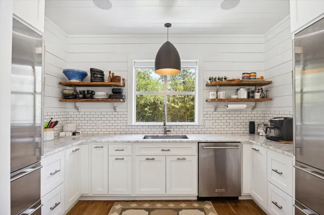 a kitchen with stainless steel appliances a sink stove and cabinets