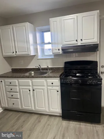 a kitchen with granite countertop white cabinets and stainless steel appliances