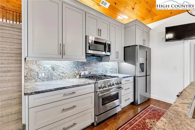 a kitchen with granite countertop wooden cabinets and stainless steel appliances