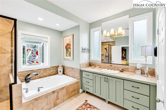 a spacious bathroom with a double vanity sink mirror and bathtub