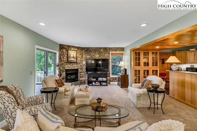 a living room with fireplace furniture and a large window