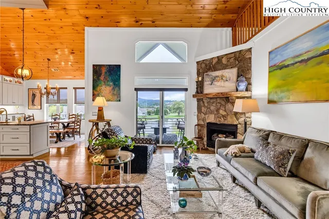 a living room with furniture large window and fireplace