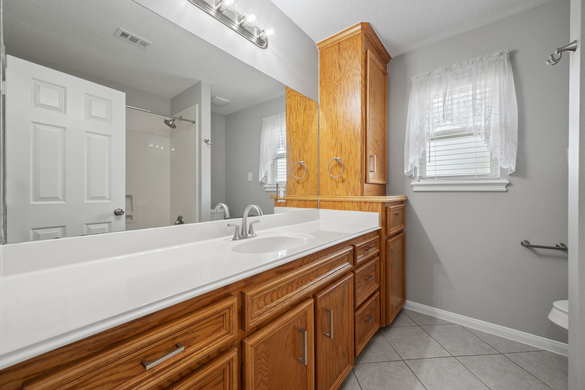 460 West Houston Street Highlands, TX 77562 - Photo 10 of 14 a spacious bathroom with a granite countertop sink and a mirror