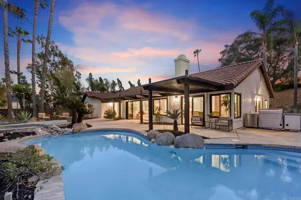 a view of a house with swimming pool and sitting area