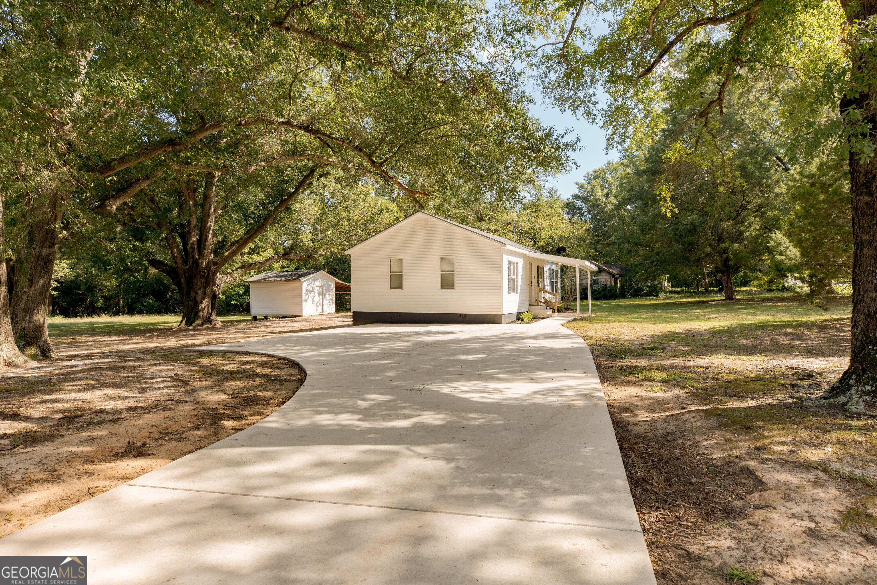 a white house with a large tree with yard