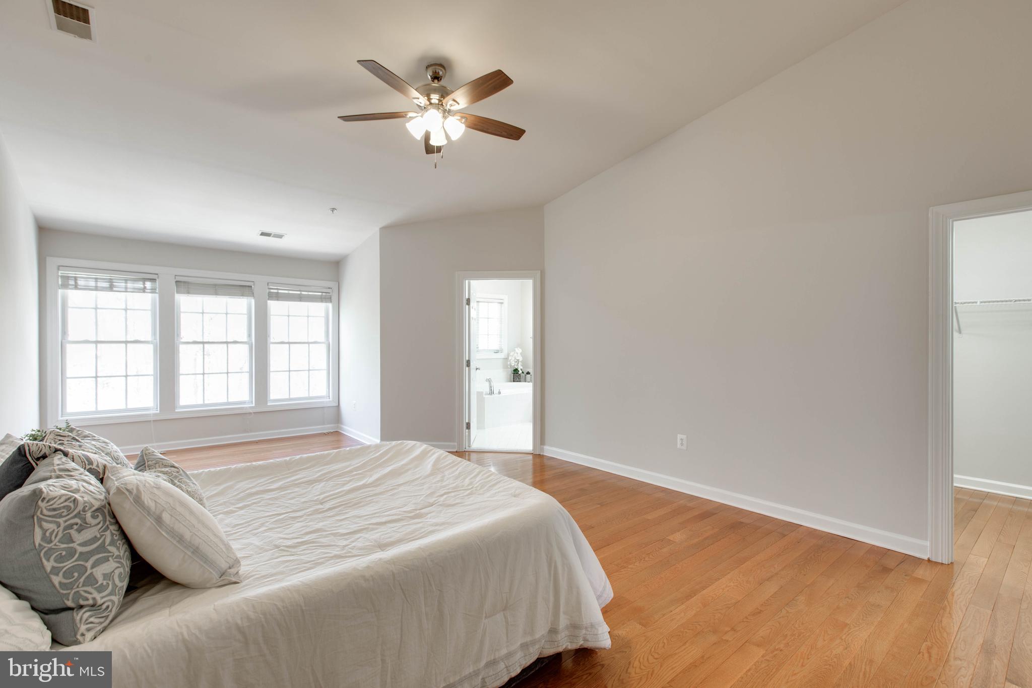 1506 Penzance Way Hanover, MD 21076 - Photo 29 of 53 a spacious bedroom with a bed and a chandelier