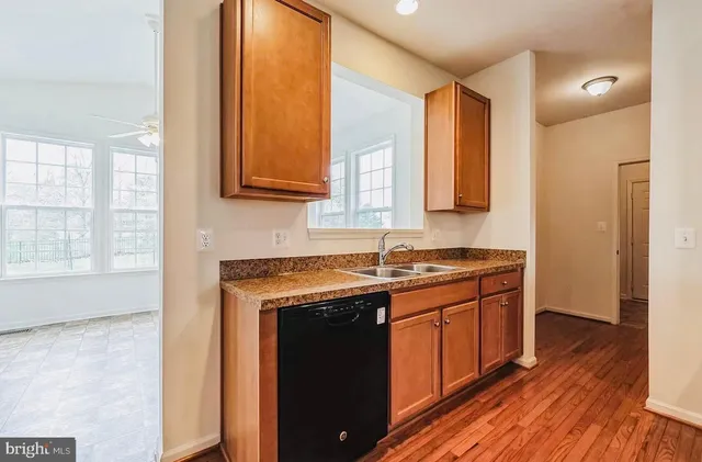 a kitchen with stainless steel appliances granite countertop a sink and wooden cabinets