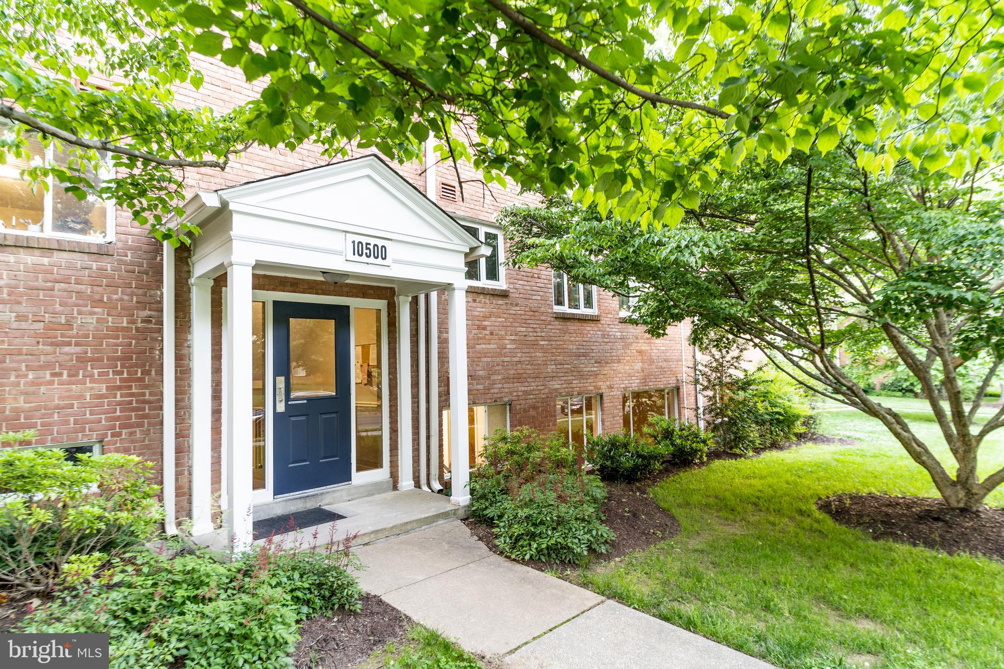10500 Montrose Avenue, Unit M4 Rockville, MD 20852 - Photo 1 of 17 a view of a white house with a big yard and large tree