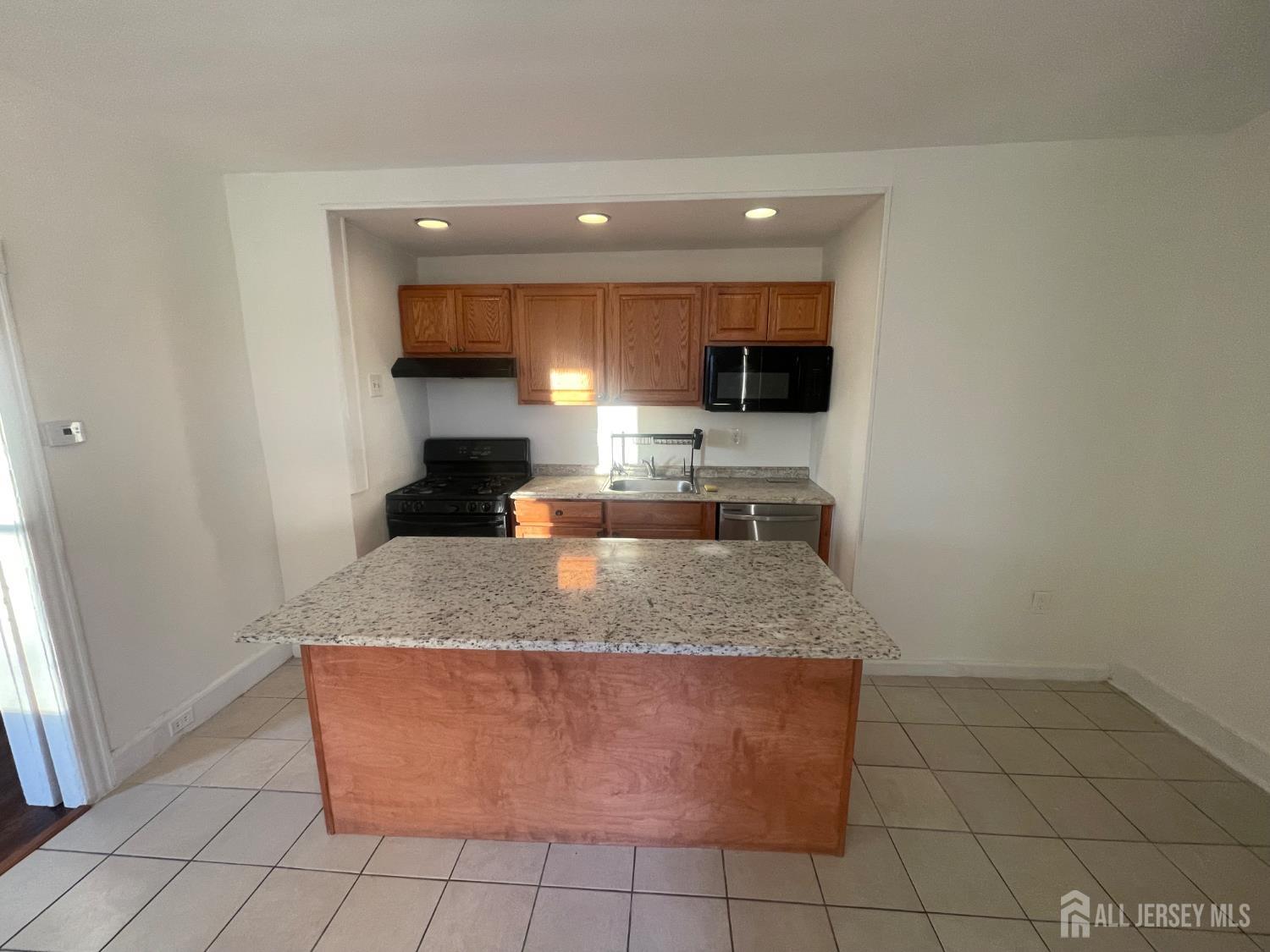 577 Rahway Avenue Woodbridge, NJ 07095 - Photo 2 of 6 a kitchen with a sink a counter top space cabinets and stainless steel appliances