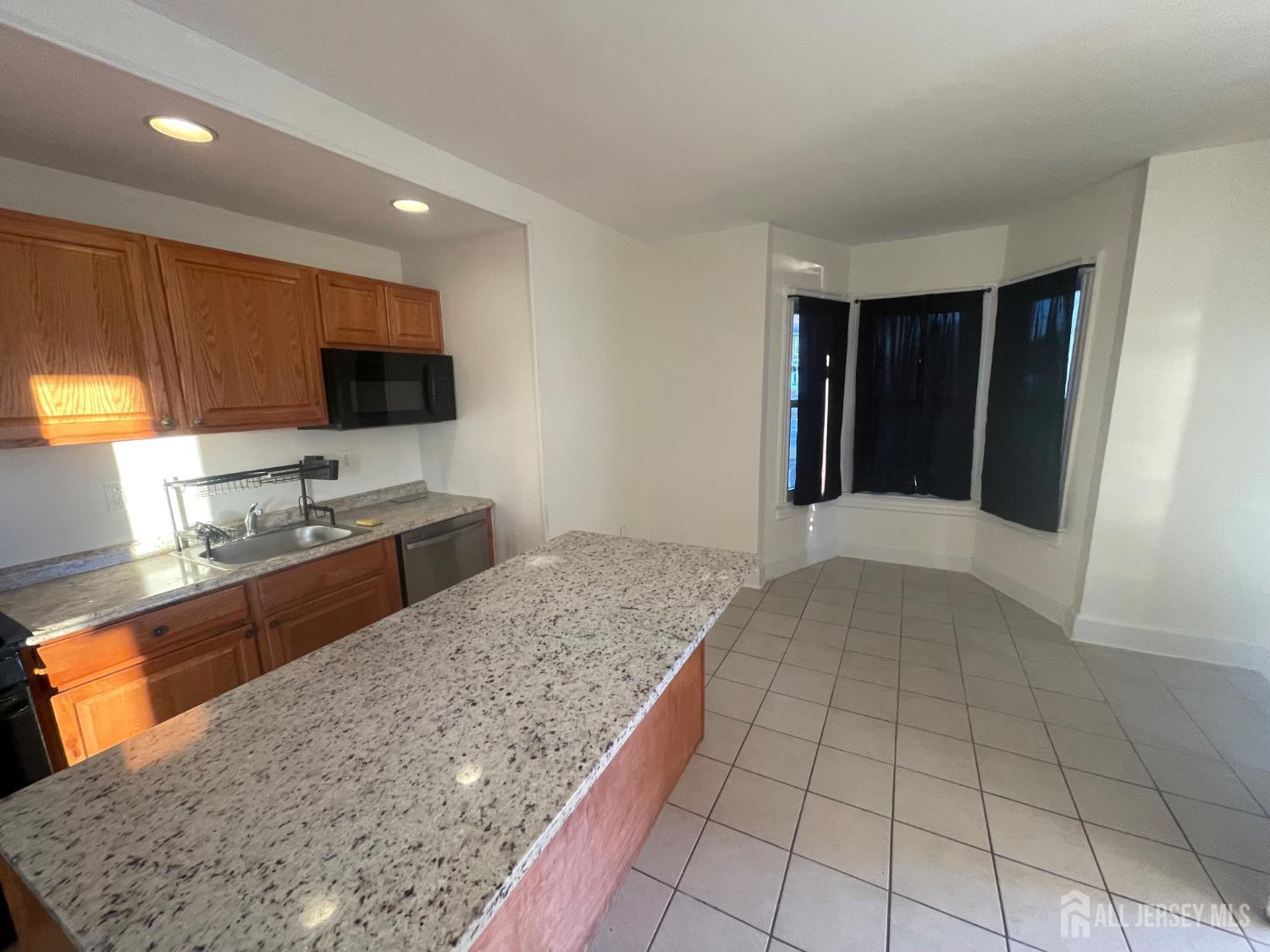 577 Rahway Avenue Woodbridge, NJ 07095 - Photo 3 of 6 a kitchen with stainless steel appliances granite countertop a sink and a stove
